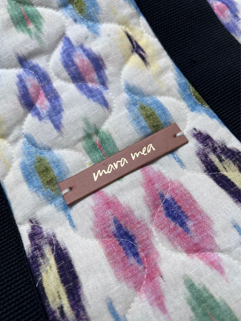 Detailaufnahme von Markenemblem von mara mea auf bunt gemusterter Shopper-Bag.