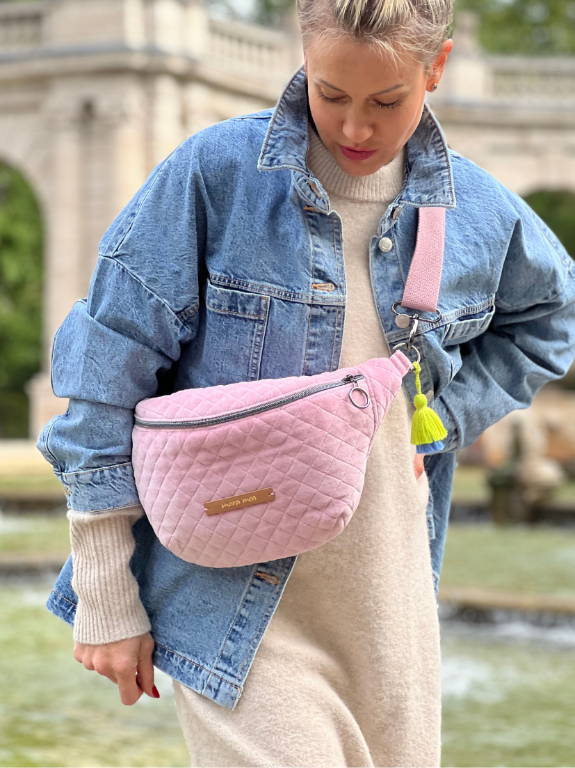 Midi Bumbag in rosafarbenem Samt und passendem Tragegurt und auffälligen Details in Grün/Blau.