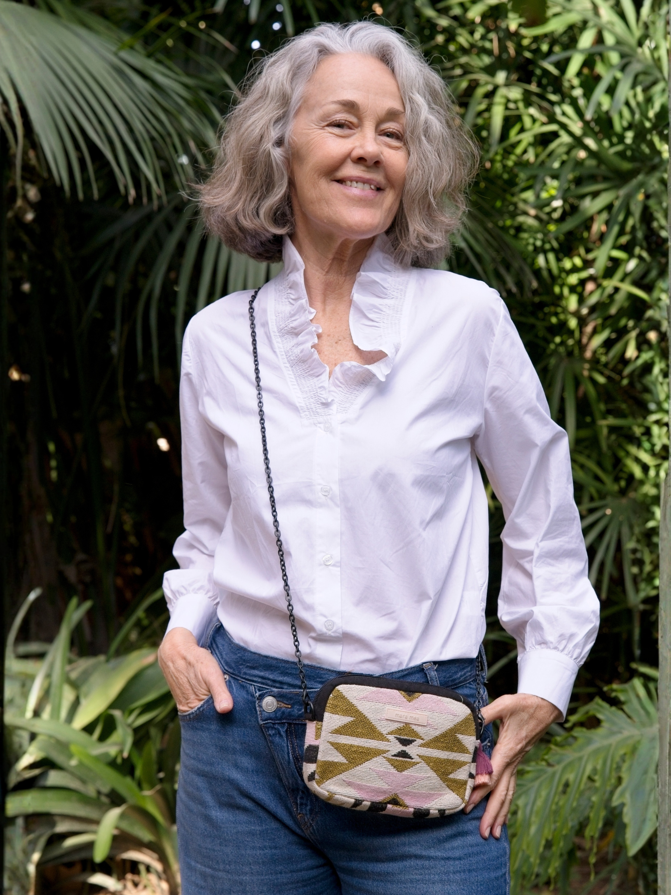 Model mit Umhängetasche press pause in graphical Muster und mit schwarzer Kette.