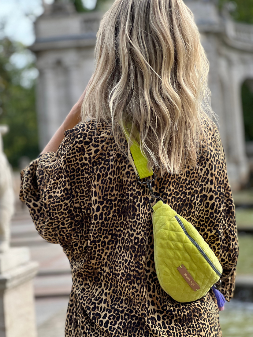 Mini-Bumbag in limettengrün quer über den Rücken getragen von blondem Model.