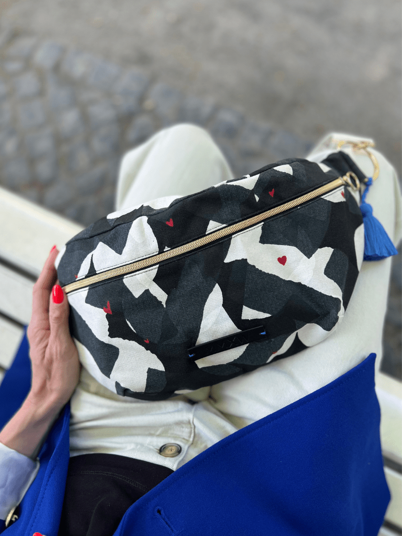 Nahaufnahme von der Maxibauchtasche in Schwarz weiß mit kleinen roten Herzen Print.