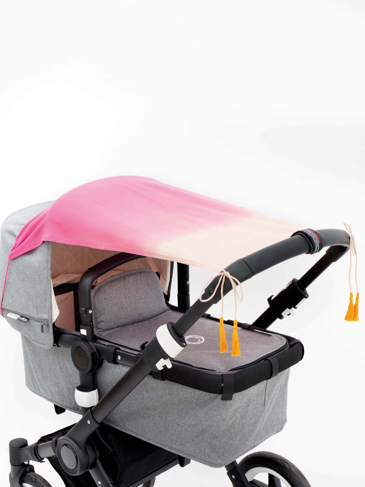 Das rote Sonnensegel frutica für den Kinderwagen von mara mea mit Gummiband zum Befestigen.