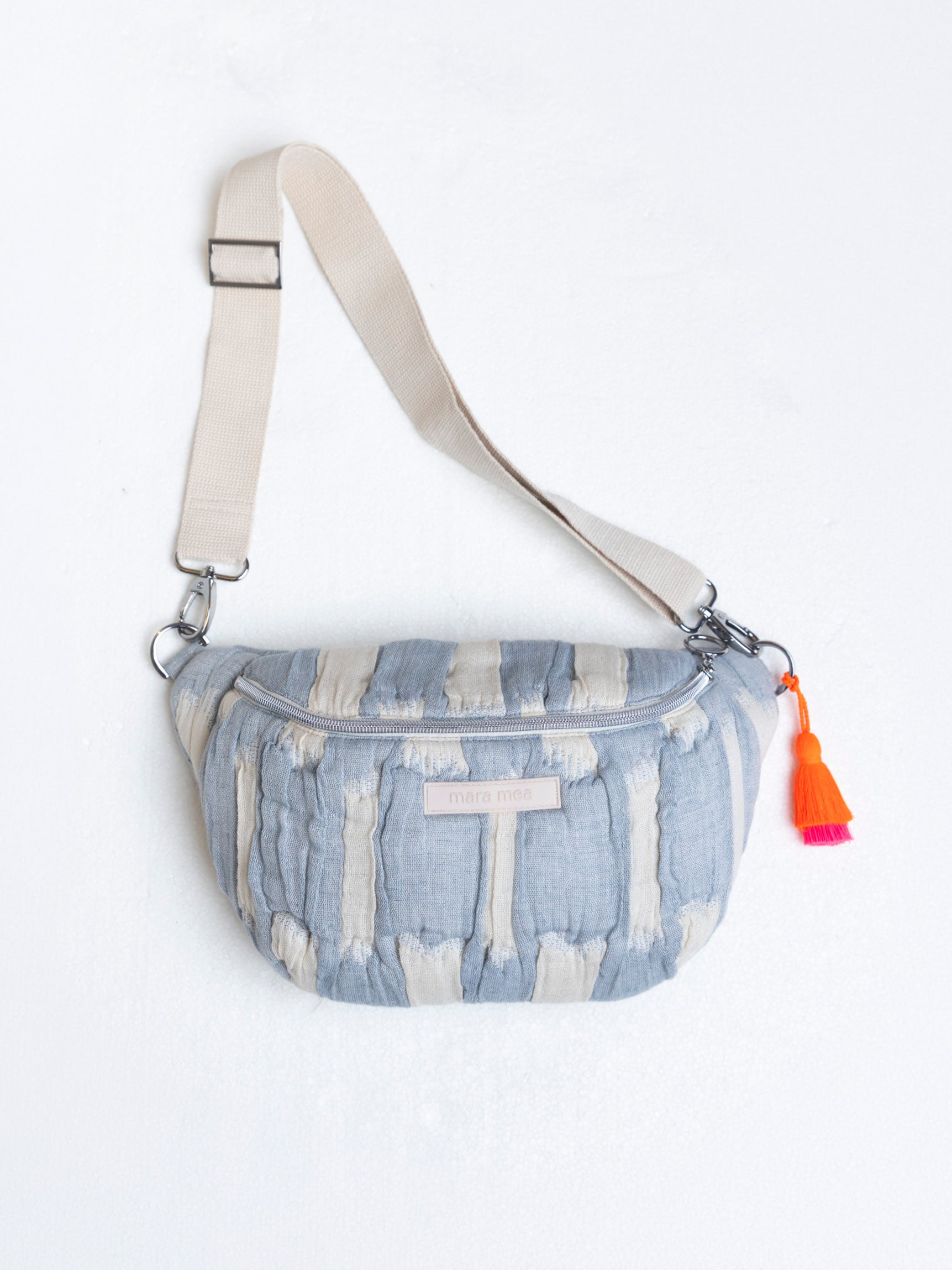 mara mea Midi Bauchtasche creamy skies in Hellblau-Offwhite mit verstellbarem Gurt, silbernem Reißverschluss und neon-orange-pinker Quaste