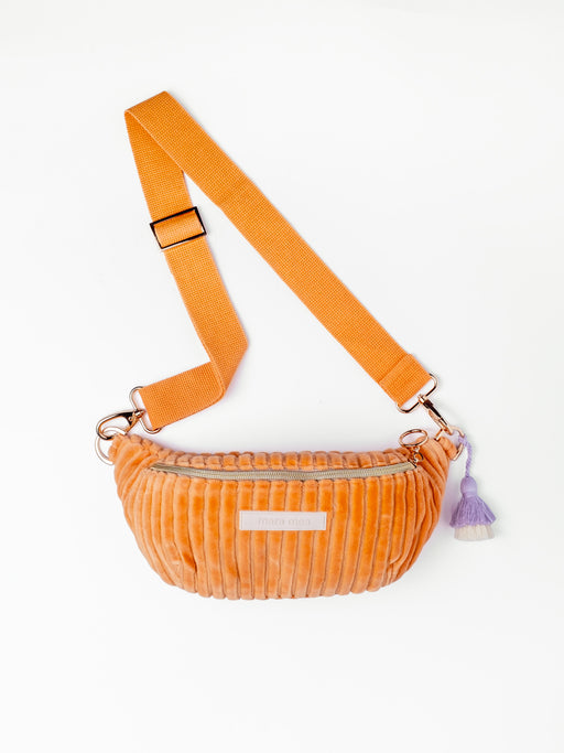 Orangefarbene mara mea Mini Bauchtasche Come Dancing Peach aus Cord mit verstellbarem Gurt, Reißverschluss und lilafarbenem Quastenanhänger auf weißem Hintergrund