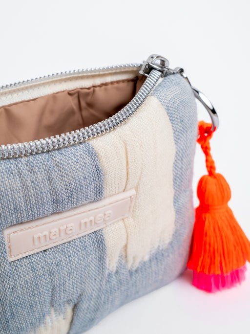 Detailansicht des mara mea Portemonnaie clouded bliss in Hellblau-Offwhite mit Markenlabel, silberfarbenem Reißverschluss und neon-orange-pinker Quaste