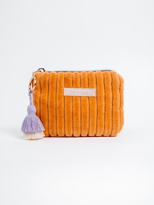 Orangefarbenes mara mea Portemonnaie Soft & Spicy Peach aus Cord mit Reißverschluss, Markenlabel und lilafarbenem Quastenanhänger auf weißem Hintergrund