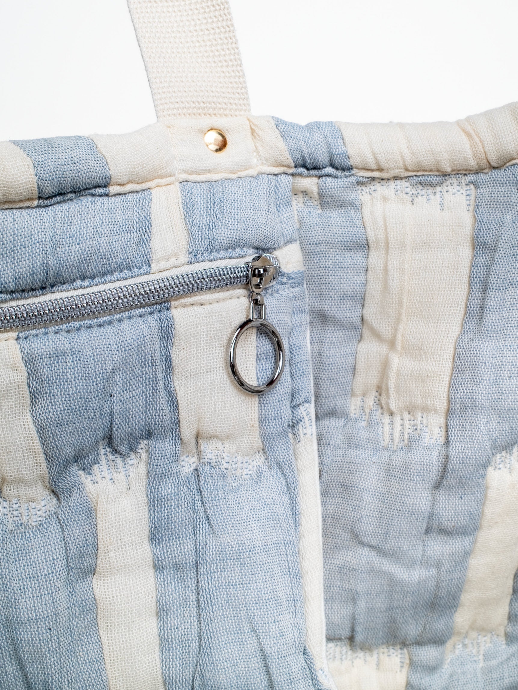 Detailansicht der mara mea Schultertasche in Hellblau-Offwhite mit innenliegendem Reißverschlussfach, silbernem Ring-Zipper und Baumwollgriff