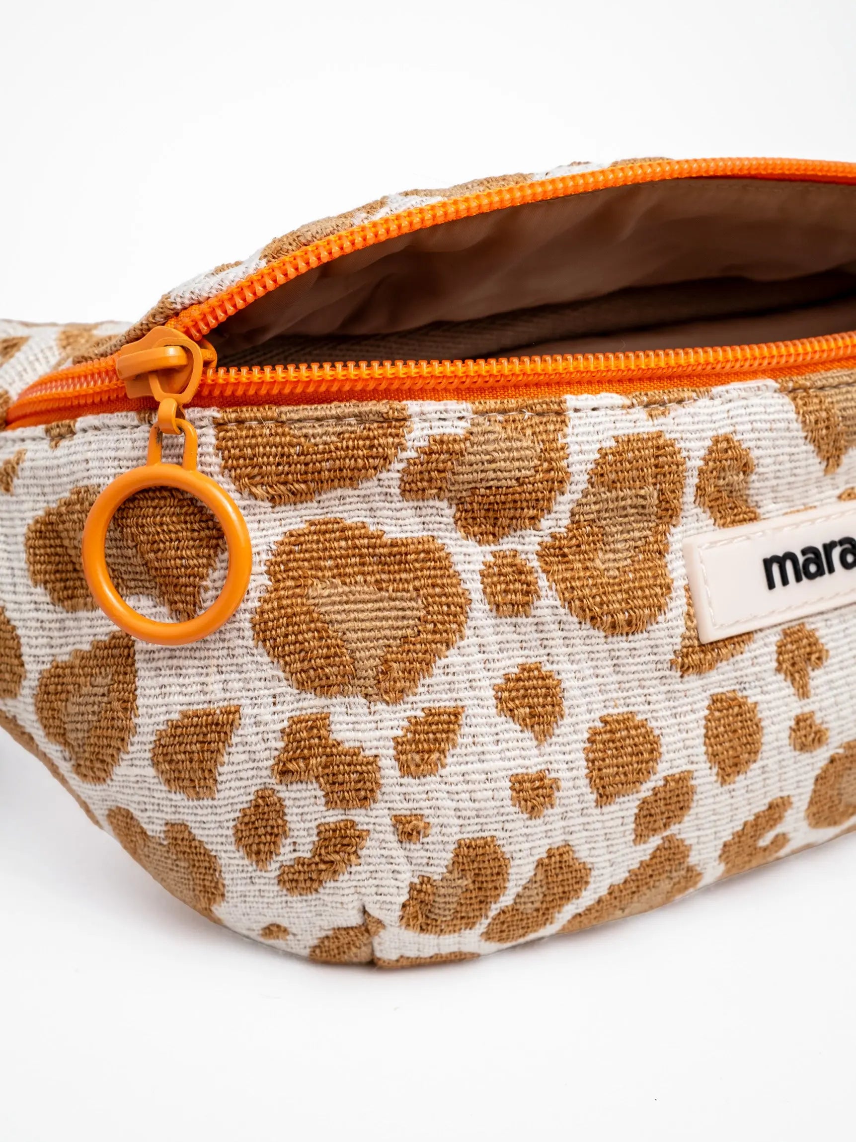 Detailaufnahme der veganen Leo Umhängetasche von mara mea mit orangefarbenem Zipper und beigefarbenem Futterstoff