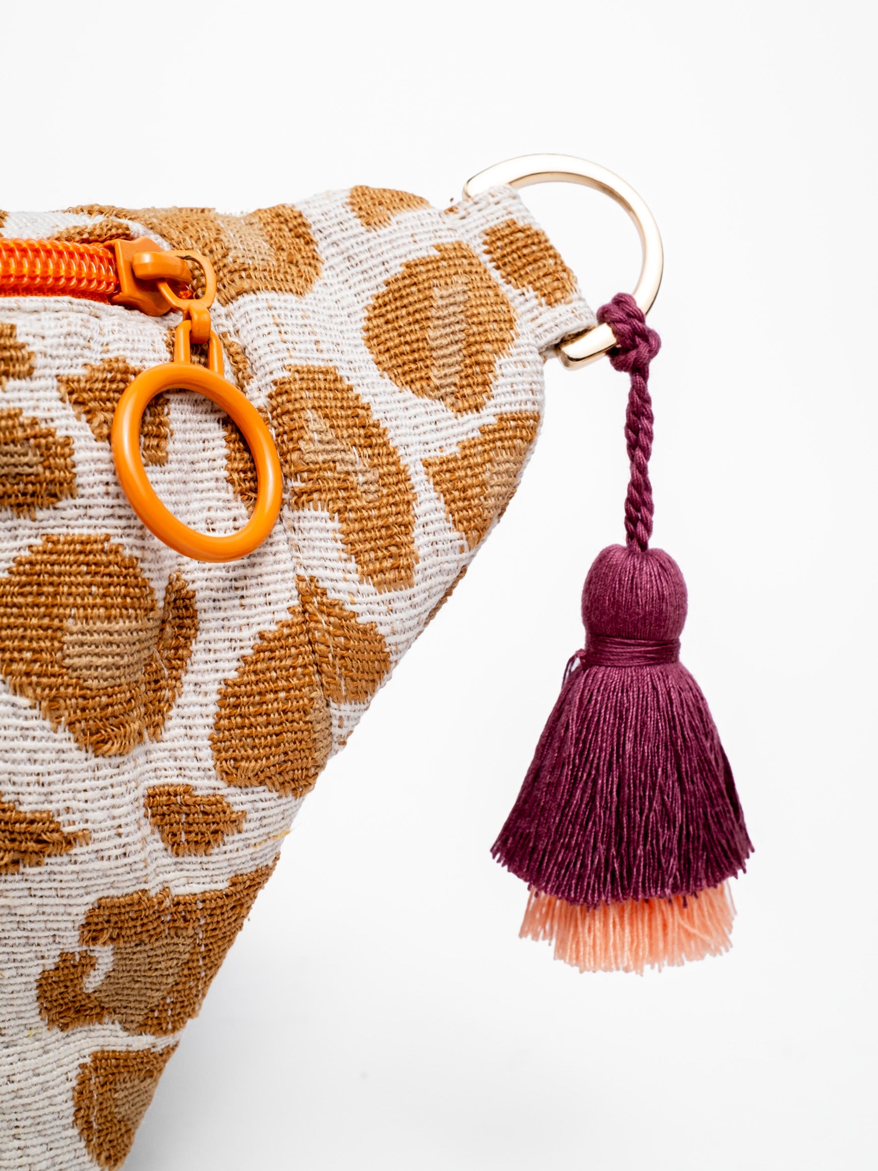 Doppelquaste in Bordeaux und Peach als handgemachtes Detail an der mara mea Leoparden Bauchtasche