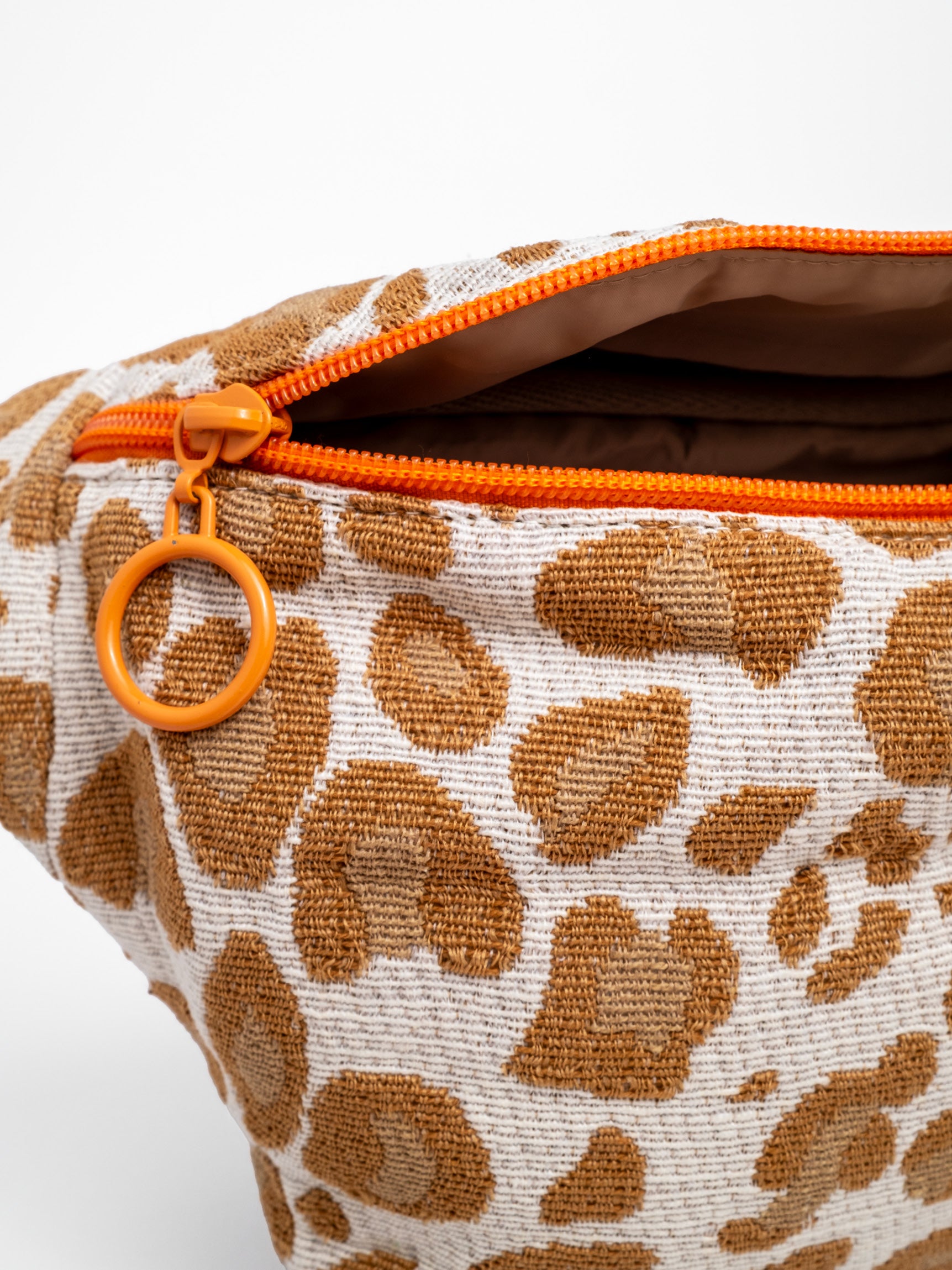 Orangefarbenes Reißverschluss Detail an Leo Bauchtasche und beigefarbenem Innenfutter