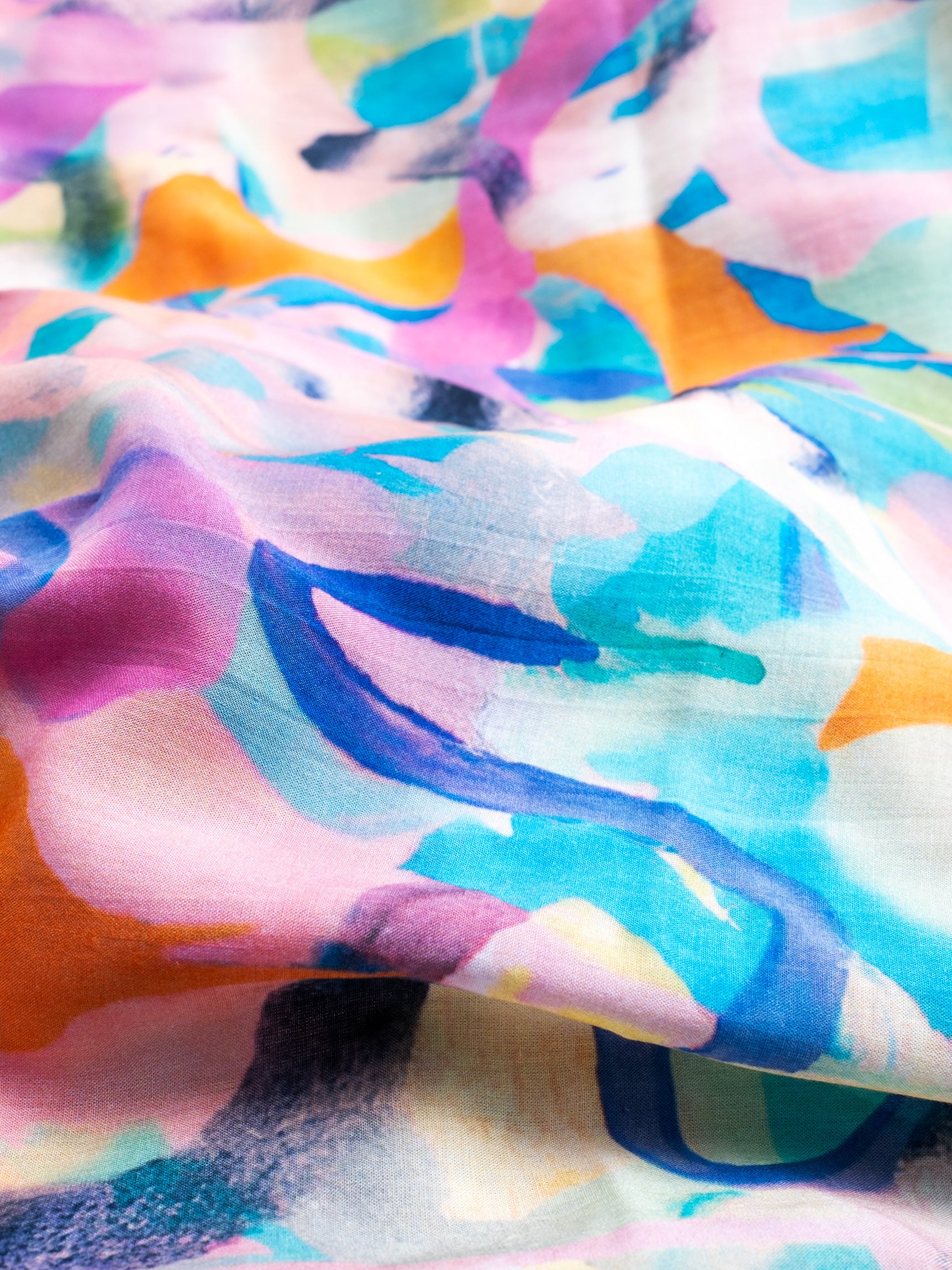 Nahaufnahme des farbenfrohen Musters des mara mea Schals Arty Farty Peach in Rosa, Türkis, Blau und Orange