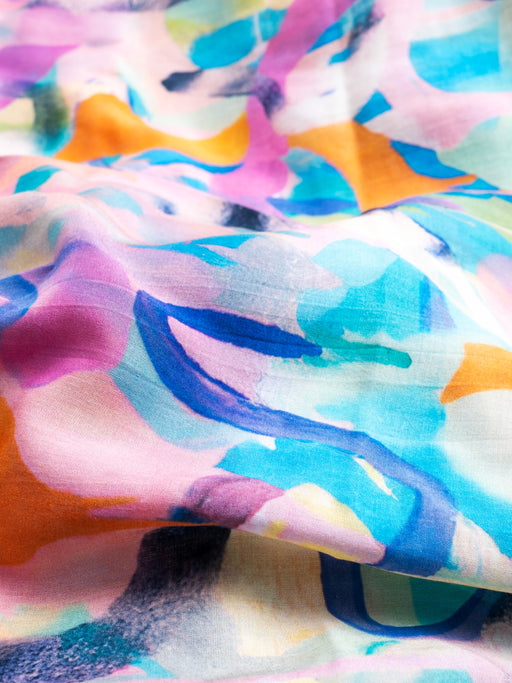 Nahaufnahme des farbenfrohen Musters des mara mea Schals Arty Farty Peach in Rosa, Türkis, Blau und Orange