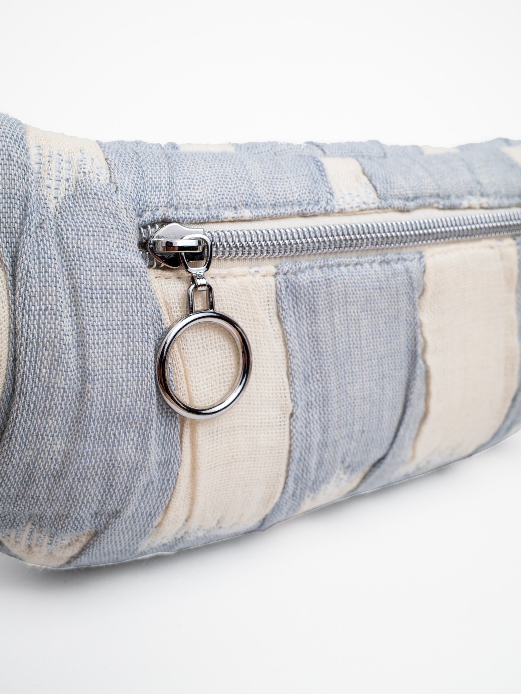 Detailansicht der mara mea Mini Bauchtasche cloud club mit rückseitigem Reißverschlussfach, Ring-Zipper und hellblau-offwhite gepolstertem Baumwollstoff