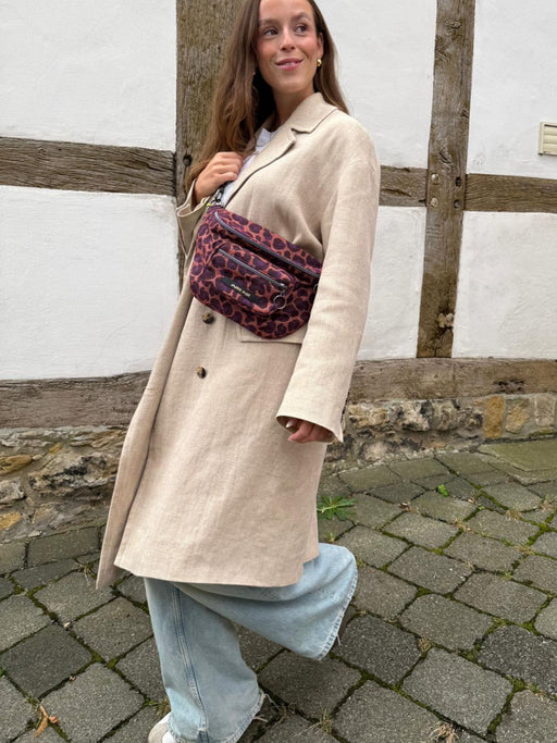 Trendy Leoparden Damenhandtasche zum Umhängen an Model mit Trenchcoat 