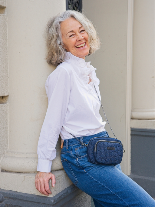 Umhängetasche aus Denim mit aufgesetzter Frontasche mit gewebten Details an älterem Model.