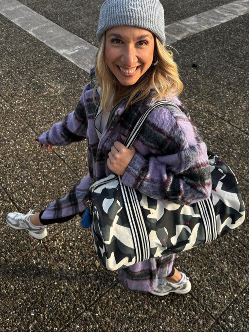 Frau mit grauer Mütze trägt die Weekender Bag amore amore über der Schulter