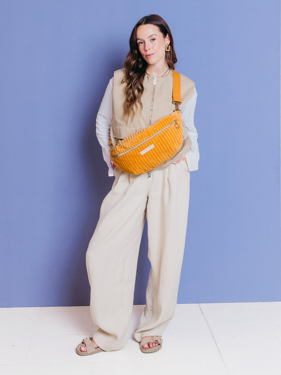 Frau trägt die Maxi Bauchtasche soft serve Peach crossbody