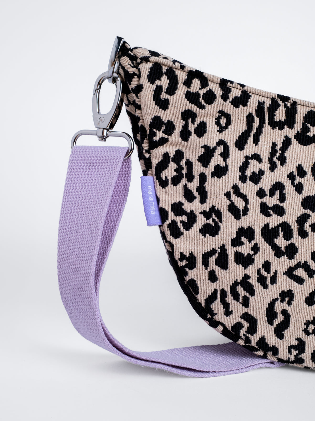 Detail der Moon Bag bloom wild mit Silber-Karabiner, fliederfarbenem Gurt und gewebtem Leo-Muster