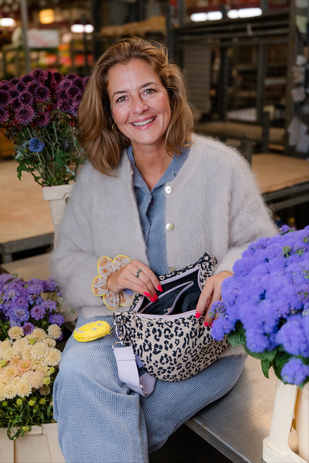 Tessa Petzoldt öffnet die Moon Bag bloom wild, daran hängt die Charm Bag, am Handgelenk der Petal Scrunchie