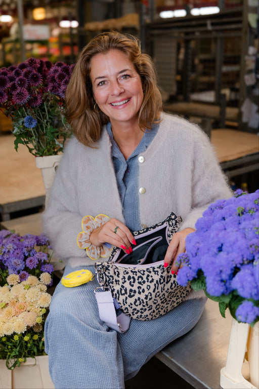 Tessa Petzoldt öffnet die Moon Bag bloom wild, daran hängt die Charm Bag, am Handgelenk der Petal Scrunchie