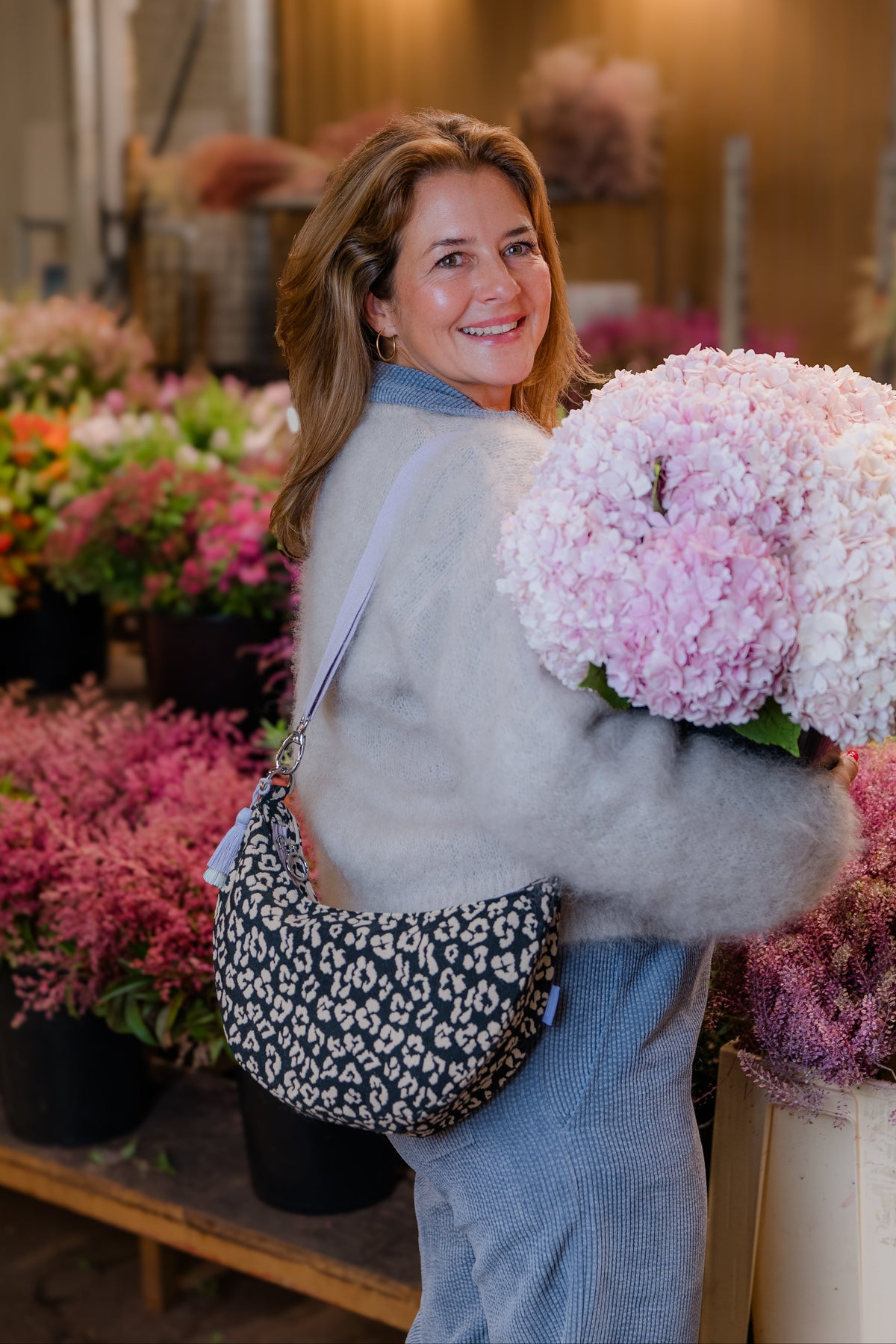 Tessa Petzoldt trägt die Moon Bag bloom wild crossbody und hält Hortensien auf dem Blumengroßmarkt