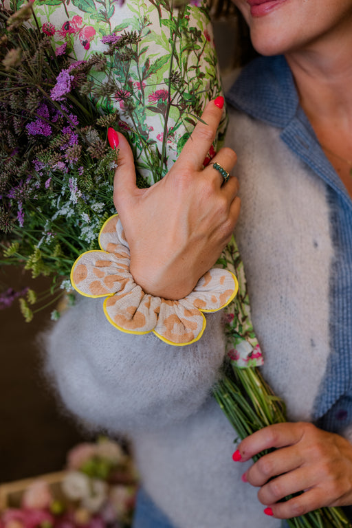 Petal Scrunchie wildflower am Handgelenk, die Hand hält einen Blumenstrauß