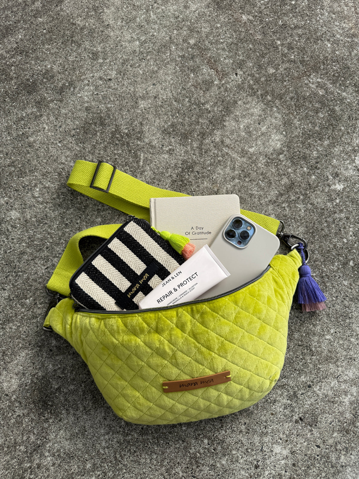 Geöffnete Midi Bauchtasche bold beauty mit gestreiftem Portemonnaie, Handy und Notizbuch
