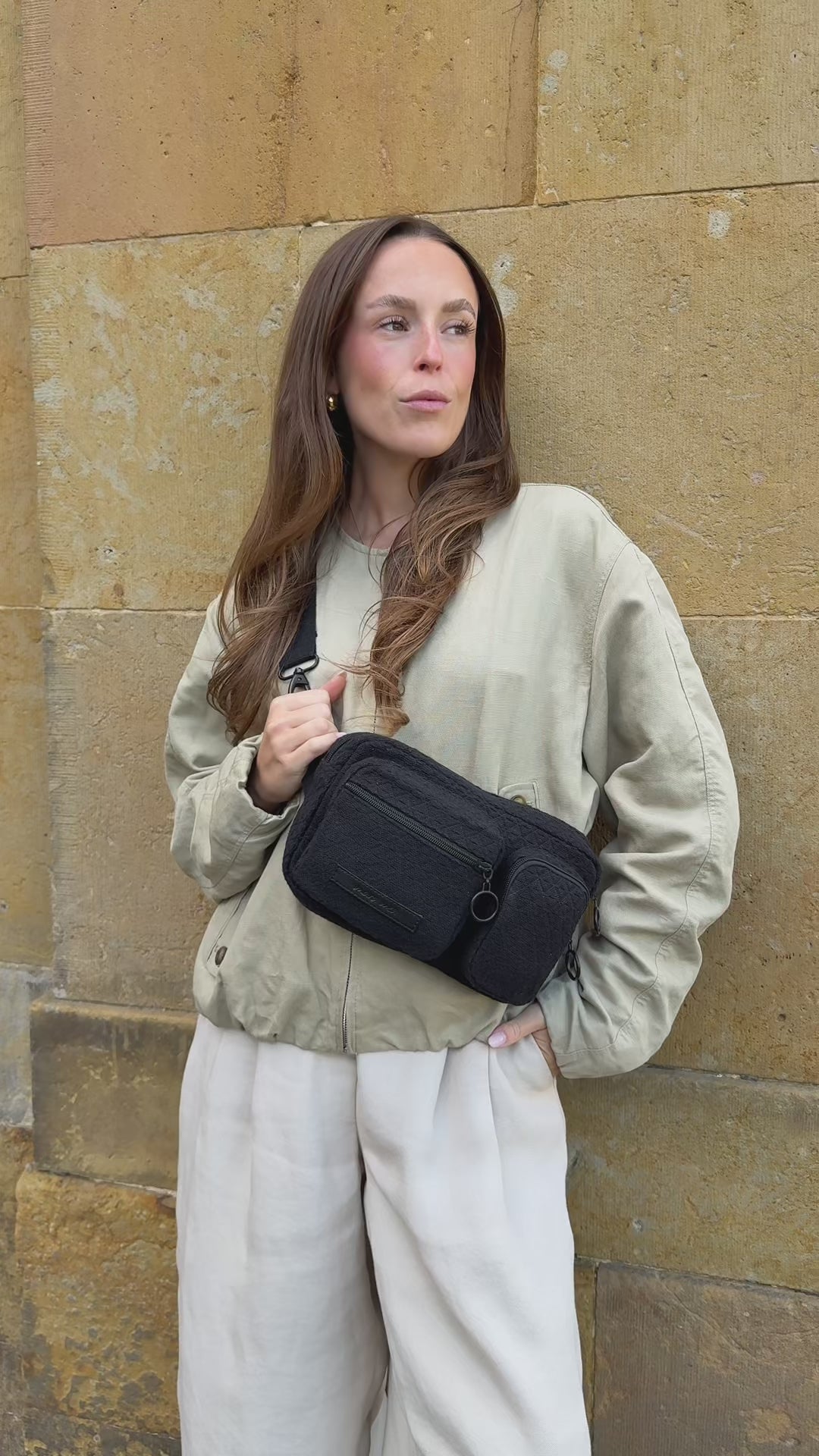 Video, Frau trägt die Hip Bag all black um die Hüfte und crossbody und holt Dinge aus den vorderen Fächern