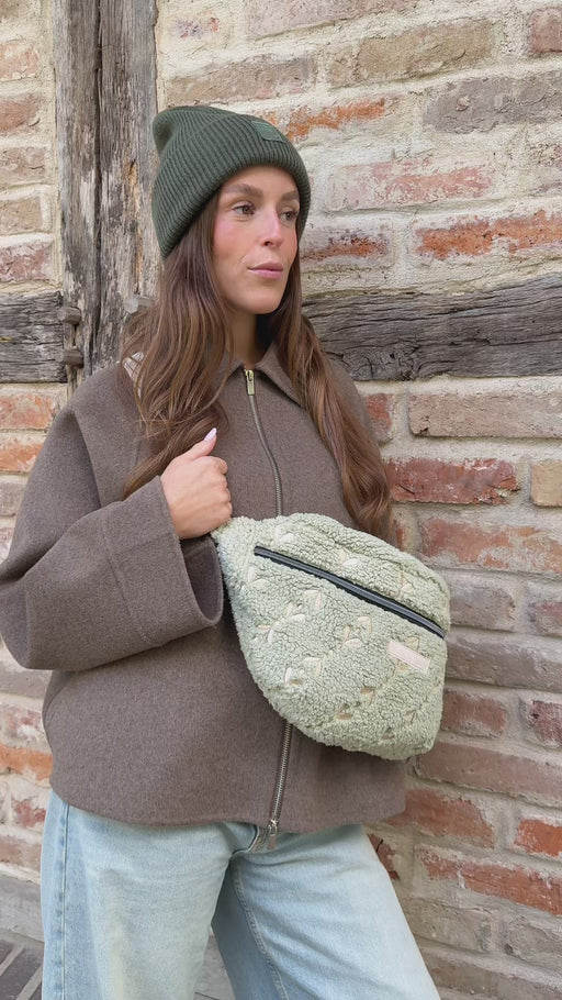 Video, Frau öffnet die Maxi Bauchtasche snuggle me, holt etwas heraus, schließt sie und trägt sie auf dem Rücken
