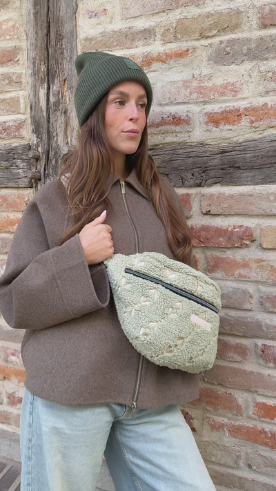 Video, Frau öffnet die Maxi Bauchtasche snuggle me, holt etwas heraus, schließt sie und trägt sie auf dem Rücken