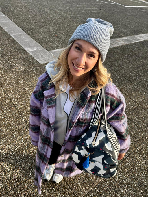 Lächelnde Frau mit der Weekender Bag amore amore über der Schulter, Blick nach oben in die Kamera