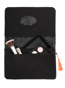 Nach der Wickelzeit können ein iPad mini und einige Kosmetik in der Windelclutch street market mit schwarz-weißem Muster verstaut werden.