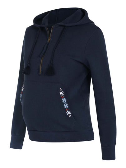 Der Umstands- und Stillpullover cozy days ist mit farblichen Stickereien und zwei Quasten ausgestattet, wodurch der Pullover seinen Boho-Style erhält.