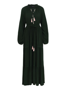 Das lange Umstandkleid b for botanist ist dunkelgrün. mit Boho-Look Stickerei, Quasten am Ausschnitt und einem Gürtel versehen.