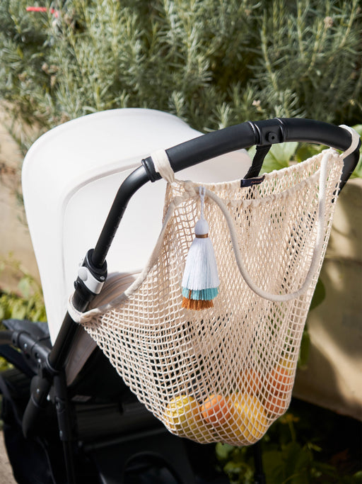 Das Kinderwagen-Netz lemon daydream in beige von mara mea kommt mit farbiger Quaste.