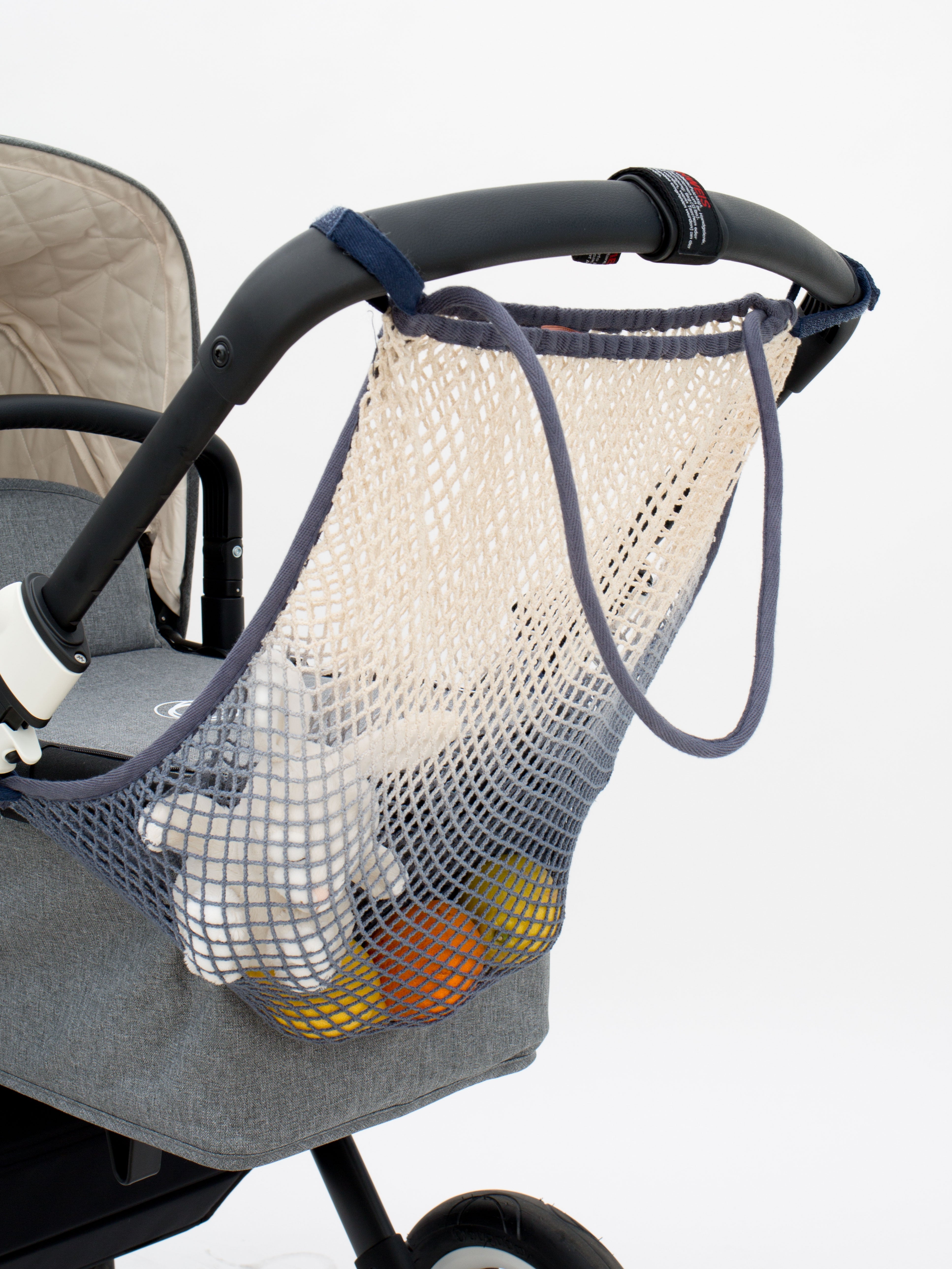 Das Kinderwagen-Netz white feather mit Farbverlauf in Grau von mara mea bietet viel Stauraum am Kinderwagen.