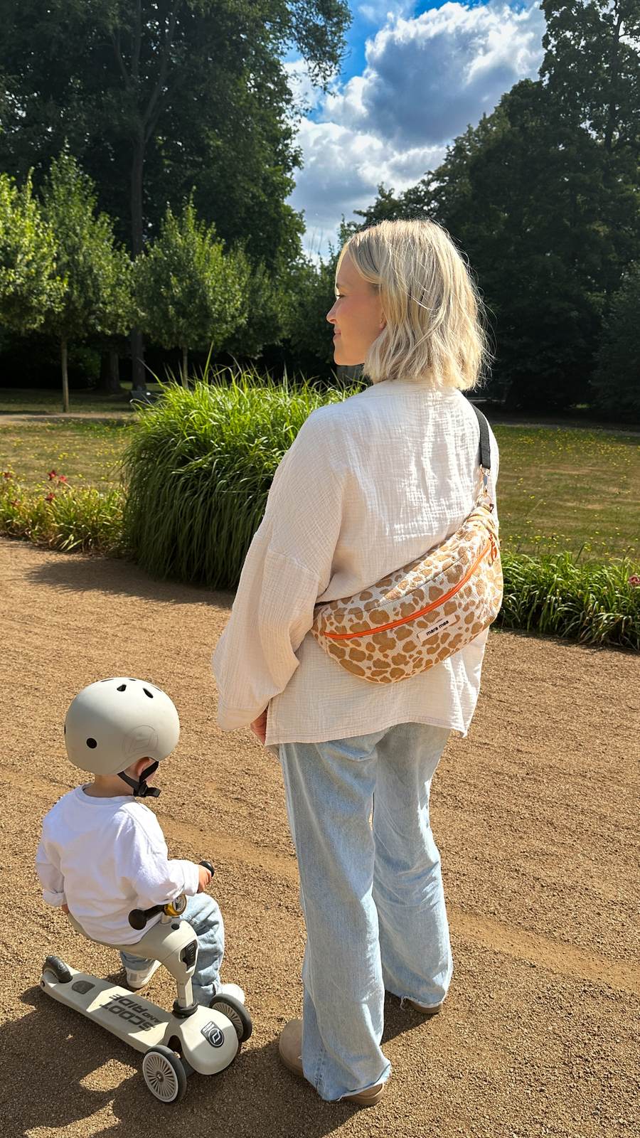 Mama mit mara mea Bauchtasche und Kind auf dem Scooter