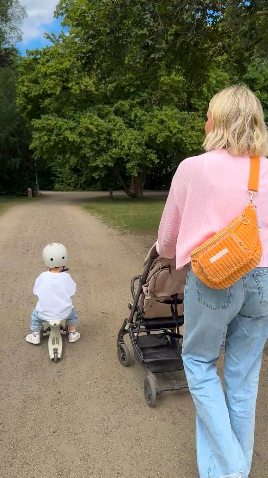 Mama in rosa Pullover mit orangefarbener mara mea Cord-Bauchtasche als Crossbody