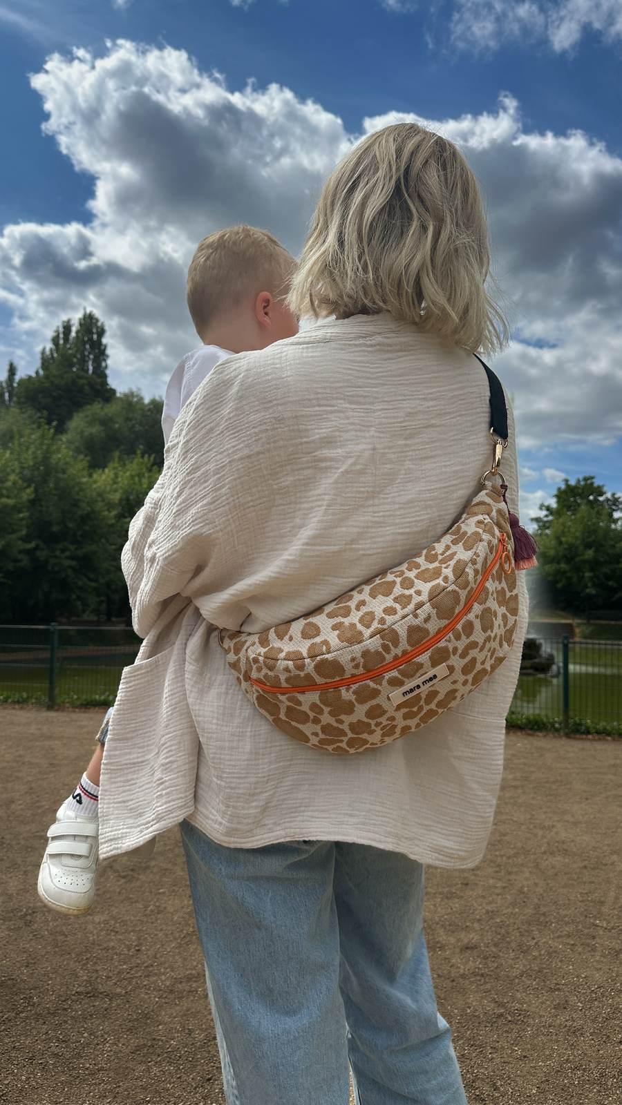 Mama trägt ihr Kind auf dem Arm – die mara mea Tasche sitzt trotzdem richtig